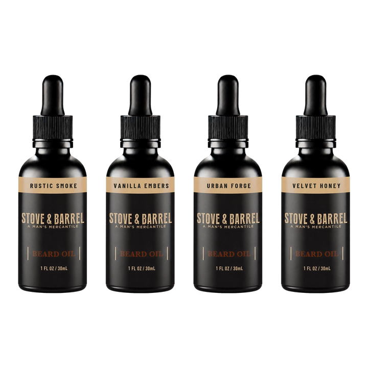 Four Stove & Barrel beard oil bottles in Rustic Smoke, Vanilla Embers, Urban Forge, and Velvet Honey scents