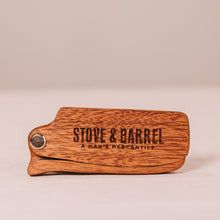 Wooden Stove & Barrel keychain with engraved logo, showcasing rustic men's grooming brand identity