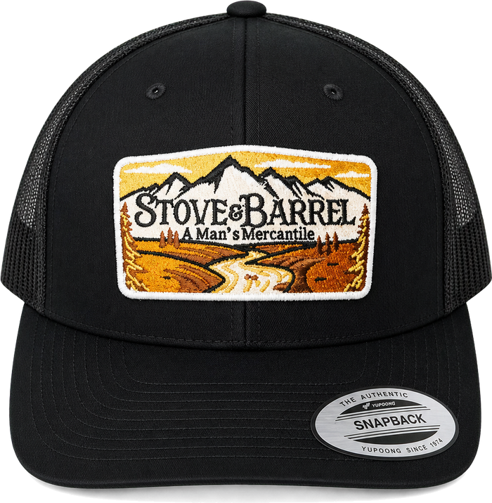 Black trucker hat with Stove & Barrel mountain patch, 'A Man's Mercantile' logo, and Yupoong snapback label